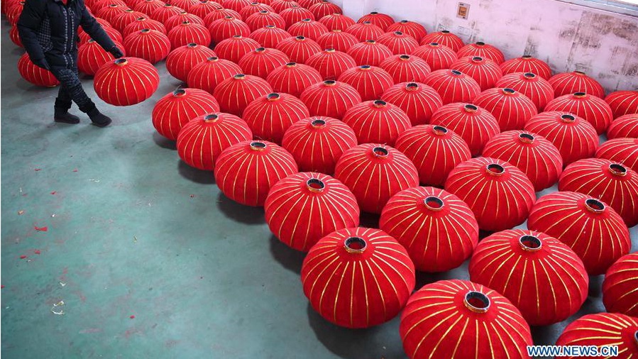 People make red lanterns for Chinese Lunar New Year